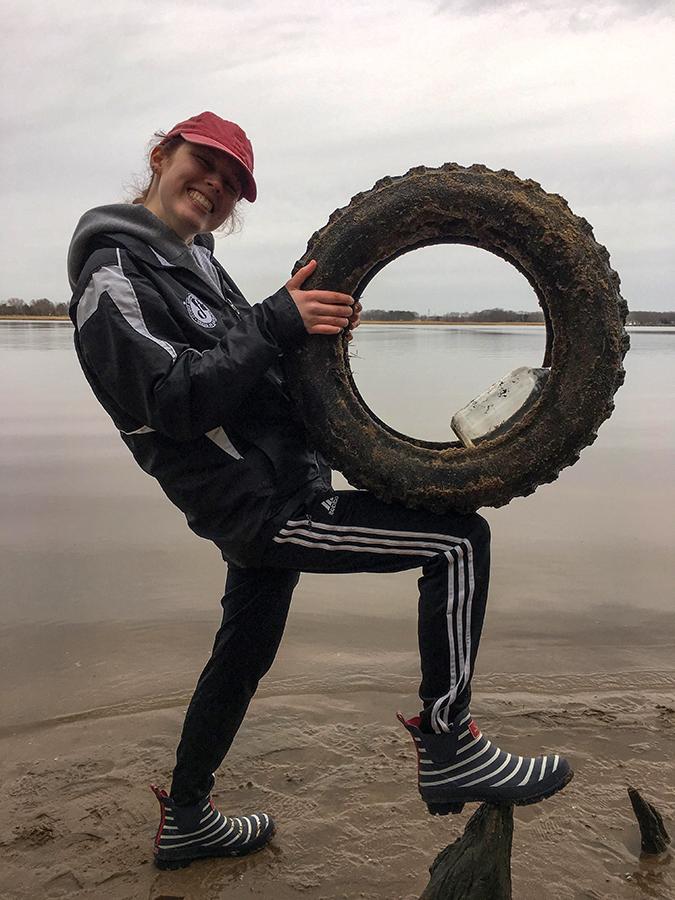 A student in 艺术 in the Anthropocens with a tire found on a Chesapeake beach